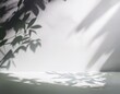 © Design and Bacon - Parede branca vazia e piso de estúdio com sombras de folhagens refletidas. Fundo minimalista para produtos ou texto.