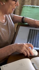 Canvas Print - Slow motion, details of elderly woman hands using a mouse with the laptop at home.