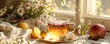 © Supannee - A cup of tea on a table by a window, with lemons, an apple and flowers.