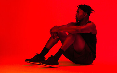 Poster - Red, lighting and man on floor in studio for ideas, fitness and wellness for memory or exercise. Athlete, thinking and relax or rest for workout, training and health for cardio by neon background