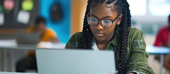 Female high school student learning coding on laptop