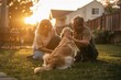 © Pelayo - Happy family playing with their dog in a backyard