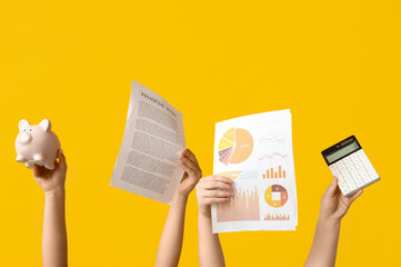 Fototapete - Female hands with documents, graphics, piggy bank and calculator on yellow background