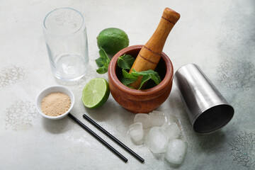 Wall Mural - Wooden mortar, pestle and ingredients for preparing mojito on grunge background, closeup