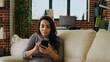 © DC Studio - Happy cheerful person chatting with online friends over the phone, enjoying herself in welcoming stylish home. Entertained woman scrolling on social media feed, camera A zoom in close up shot