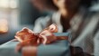 © svastix - A woman holding out a beautifully wrapped gift box with a pink ribbon, exemplifying the personal touch and affection inherent in thoughtful gift-giving moments.
