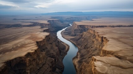 A breathtaking aerial perspective of a winding river carving its way through a vast and rugged canyon, revealing the sheer scale and beauty of nature's craftsmanship.