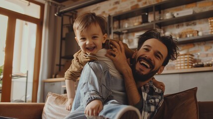 Wall Mural - A joyous father and his young son are interacting playfully and laughing together on a sofa in a warmly lit room, enjoying quality time and strengthening their bond.