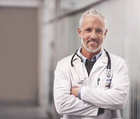 Poster - Let me help take care of your overall health. Portrait of a mature male doctor standing in a hospital.