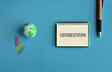 There is notebook with the word Reforestation. It is as an eye-catching image.