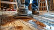 © INT888 - Action image of a worker using a floor buffer to sand a hardwood surface in preparation for refinishing