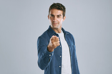 Poster - Pointing, portrait and man in studio, confident and choice of you, recruitment and employee in mockup. Blue background, face and gesture of person, hiring and hand for opinion, fashion and space