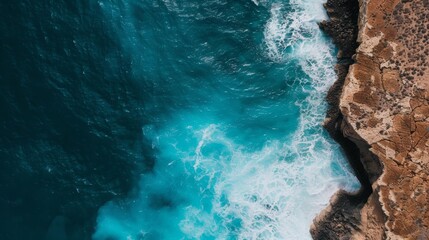 Seaside cliffs with waves crashing against them, the textured rock formations contrasting with the bright blue ocean