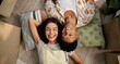 © CineLens2024/peopleimages.com - Couple, above and happy on new home floor, happiness and love for relationship or moving with boxes. Relax, property investment and together in apartment living room, care and homeowners smile
