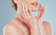 © Michael Cunningham/peopleimages.com - Skincare, lips and woman in studio with cosmetics, beauty and salon aesthetic on blue background. Dermatology, spa and closeup of person with hands on face for facial treatment, lip filler and makeup