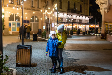 Wall Mural - Mother and daughter are walking around the city on Christmas and New Year holidays