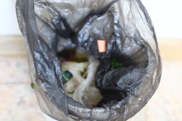 Poster - A plastic bag filled with trash and litter on the ground, highlighting environmental concerns about waste management.