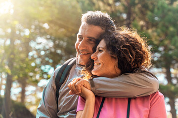 authentic middle aged couple embracing and smiling in nature, romantic relationship lifestyle portra