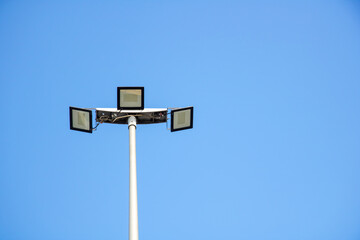 A street light stands tall against the backdrop of a clear blue sky