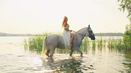 Wall Mural - Fantasy woman queen sits astride white horse hoof splashes water, fairy tale princess girl rider riding mare pet wet animal walks in river sea lake, sun light sky tree. lady elf back rear view art 4k