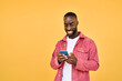 © insta_photos - Young happy smiling African American Black hipster man user customer with cellphone in hands standing isolated on yellow background holding smartphone using mobile cell phone scrolling social media.