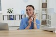 © New Africa - Professional receptionist talking on phone at wooden desk in hospital