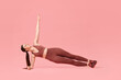 © New Africa - Young woman doing aerobic exercise on pink background