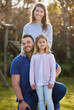 © CineLens2024/peopleimages.com - Man, woman and girl with portrait in garden for holiday, together in England with smile. Happy family, outdoor and solidarity for vacation or travel with love, wellness or support in adventure park