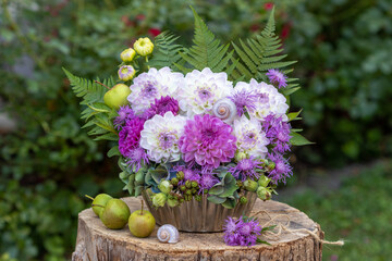 Wall Mural - Blumen-Arrangement mit Dahlien, Wiesen-Flockenblumen, Hortensienblüten, Haselnüssen, Brombeeren, Farnblättern, Apfel und Schneckenhaus in einer alten Backform