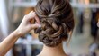 © Plaifah - A professional woman with elegant updo hairstyle, preparing for a formal event