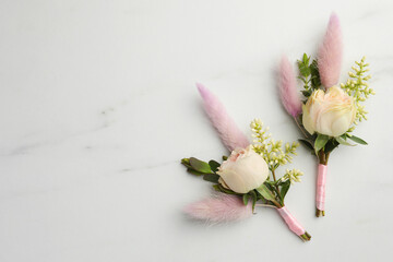 Sticker - Small stylish boutonnieres on white marble table, top view. Space for text