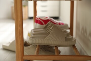 Poster - Pairs of slippers and sneakers on shoe rack at home