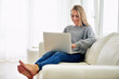 © AK Coop/peopleimages.com - Study, sofa and woman on laptop for research, social media and email at home. Female student, smile and tech in living room for education, elearning and feedback on online group project in house