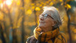 © jechm - Elderly woman enjoying autumn sunlight in the park. Senior and mature concept