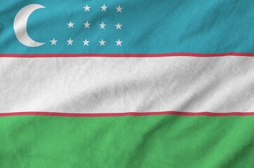 Wall Mural - Uzbekistan flag depicted on folded wavy fabric of old cloth close up