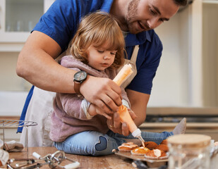 Wall Mural - Cupcake frost, baking and dad with child in kitchen with recipe for bonding, learning and fun together. Family, home and happy father and girl help with decoration for cake, dessert and sweet treats