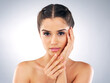 © peopleimages.com - Portrait, touch and skincare of woman with glow, shine or health isolated on white studio background. Face, makeup or confident model in cosmetics at spa for beauty treatment, dermatology or wellness