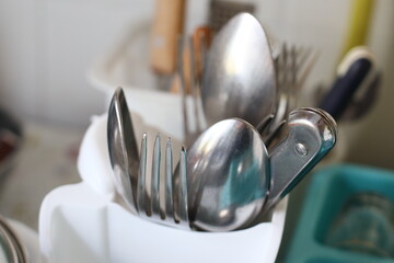 Poster - Collection of shiny silver utensils arranged neatly in a container, ideal for displaying or using as props.