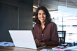 © Stock 4 You - Portrait 30s latin hispanic business woman manager working on laptop computer in modern office. Smiling Indian young businesswoman professional entrepreneur using pc app at workplace looking at camera