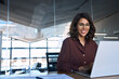 © Stock 4 You - Happy latin hispanic young business woman working on laptop computer in company office. Smiling Indian entrepreneur manager businesswoman using pc for communication, learning at workplace. Copy space