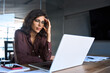 © Stock 4 You - Focused young businesswoman looking at laptop pc computer screen having headache, migraine. Latin business woman holding hand near temples, feeling stressed and tired sitting at workplace in office