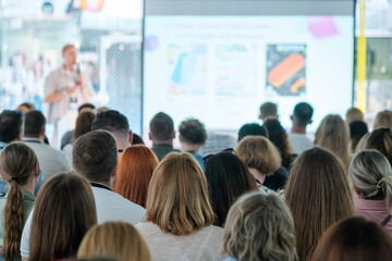 Wall Mural - large audience attentively listens to a speaker during a business conference seminar, featuring a pr