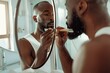 © pasiporn - man trimming beard, looking in mirror, bathroom setting