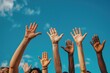 © Alina - Multiethnic men and women raising hands up on blue sky background