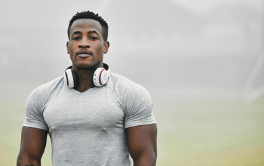 Serious, fitness and music with black man in park for exercise, streaming and cardio. Health, bodybuilding and workout with portrait of runner training in nature for sports, performance and wellness