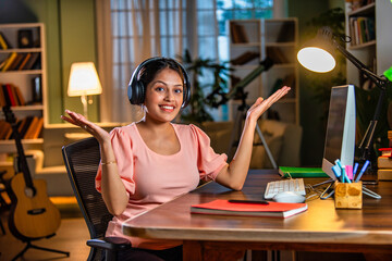 Wall Mural - Indian asian  young student or businesswoman using laptop with coffee, books, smartphone, headphone