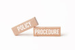 © Min Wan - Two wooden blocks with 'policy' and 'procedure' written on them.