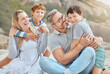 © peopleimages.com - Parents, kids and hug at beach with portrait, smile and bonding with love on vacation in summer. Father, mother and boy children on holiday for connection, embrace and family on ground in sunshine