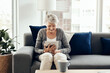 © ReeseArcurs/peopleimages.com - Senior woman, tablet and home with online, game app or social media scroll for news in retirement. Lounge, sofa and smile with web, tech and relax in living room with soap opera streaming at morning