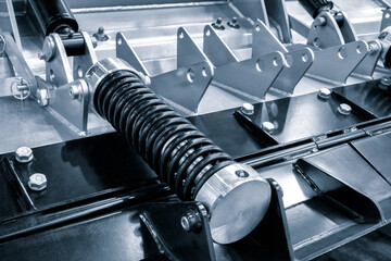 Poster - A black spring is attached to a metal piece. The spring is bent and twisted